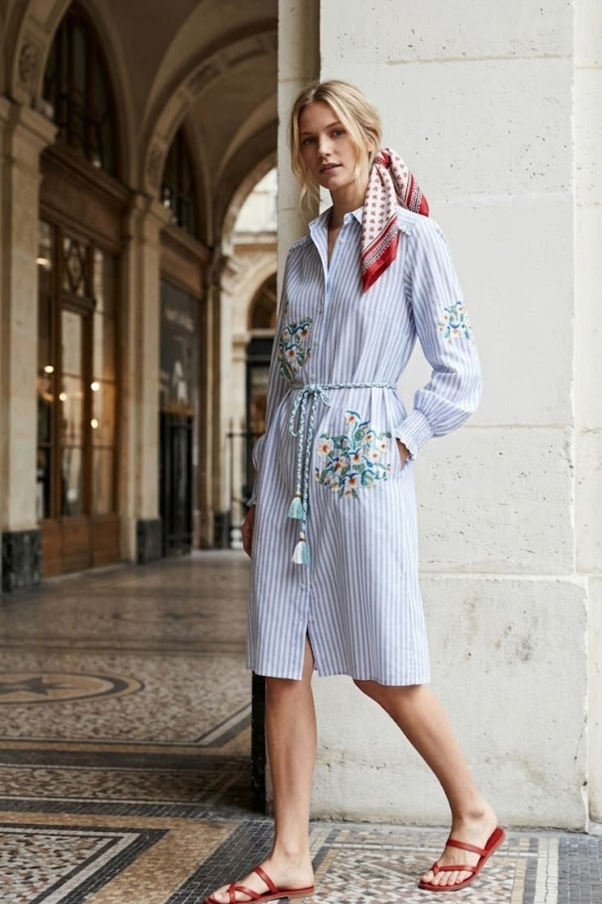 Robe chemise longueur midi à manches longues avec col chemisier classique, ornée de broderies florales délicates.